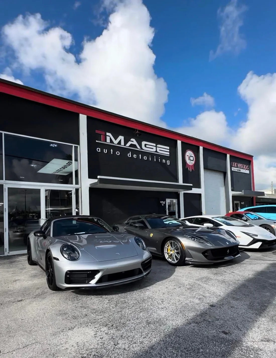 IMAGE storefront with a Porsche 911, Ferrari 812 and Lamborghini out front